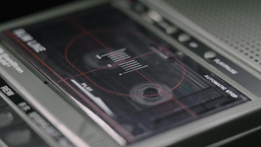 The cassette tape is spinning in the player