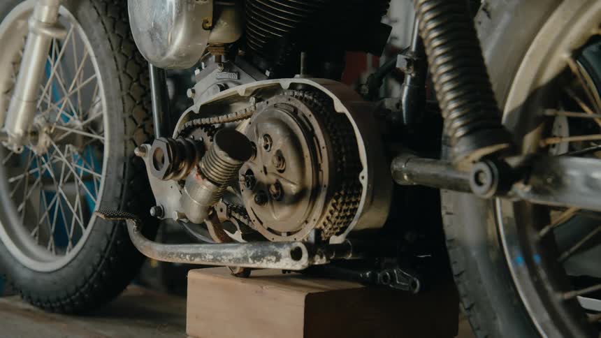 Close up of the engine of a motorcycle parked inside a garage