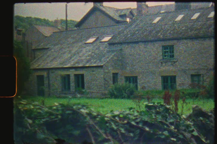 Film footage of a house in a suburban area during spring is displayed