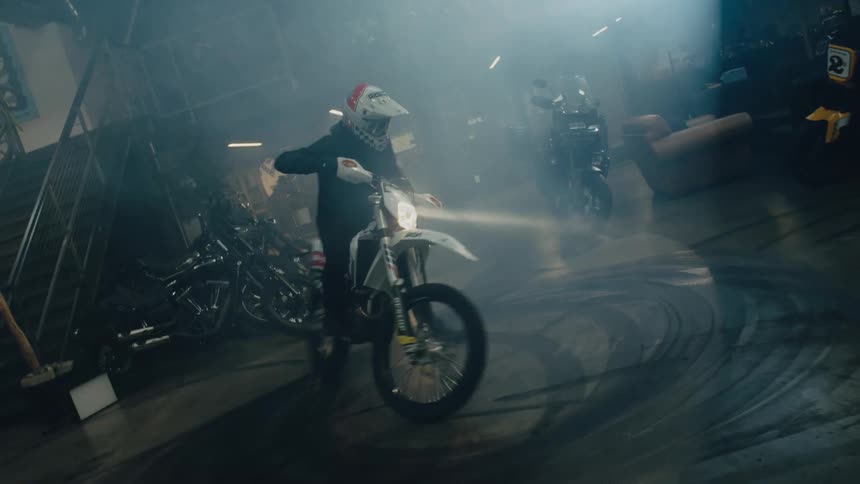 A man rides a motorcycle around in circles in a garage