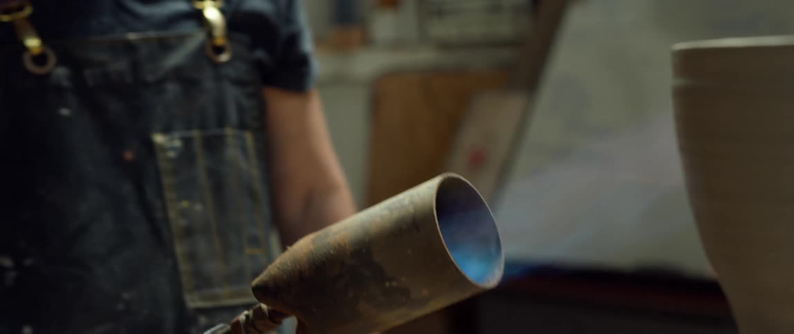 A man is putting a flame on his sculpture