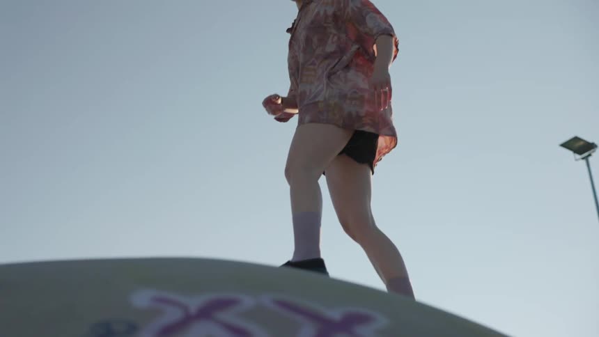 A girl is skateboarding downhill at a park