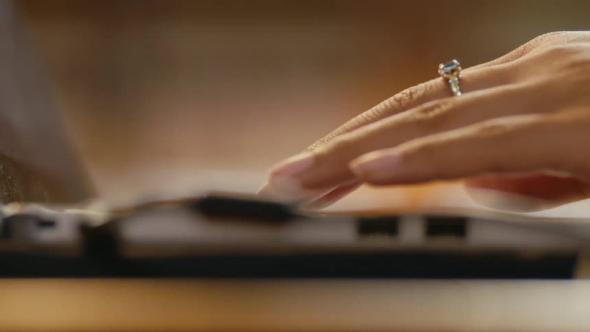 Close up of a woman's hands typing on laptop