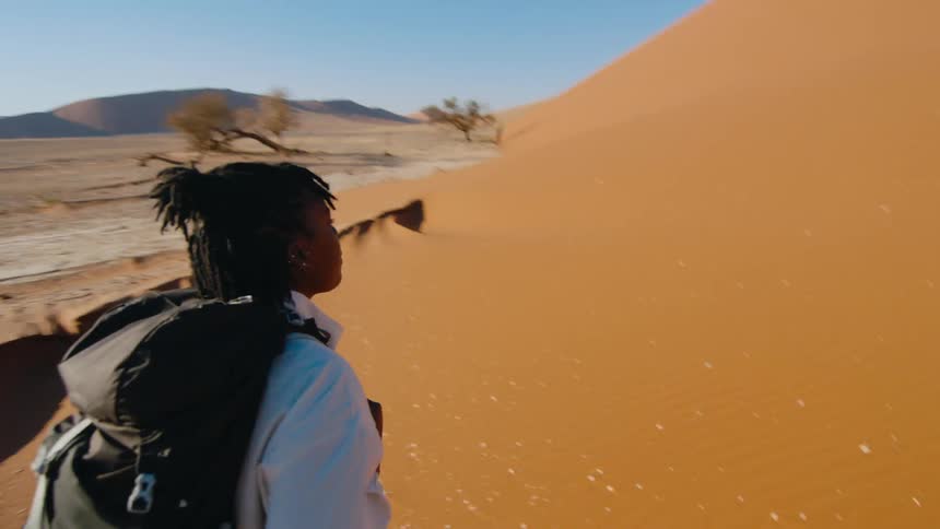 Black woman hiking through the desert