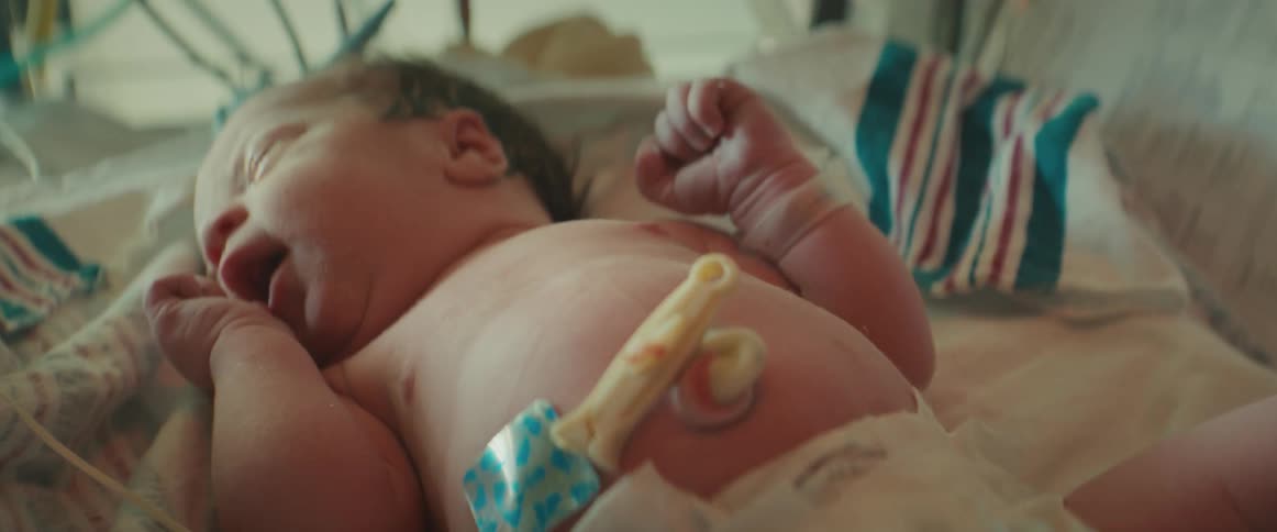 A newly born infant laying in a pediatric medical bed in the hospital