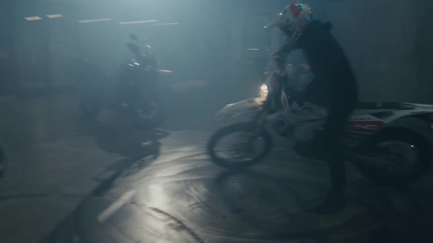 In parking garage rider moves motorcycle through a circle leaving rubber