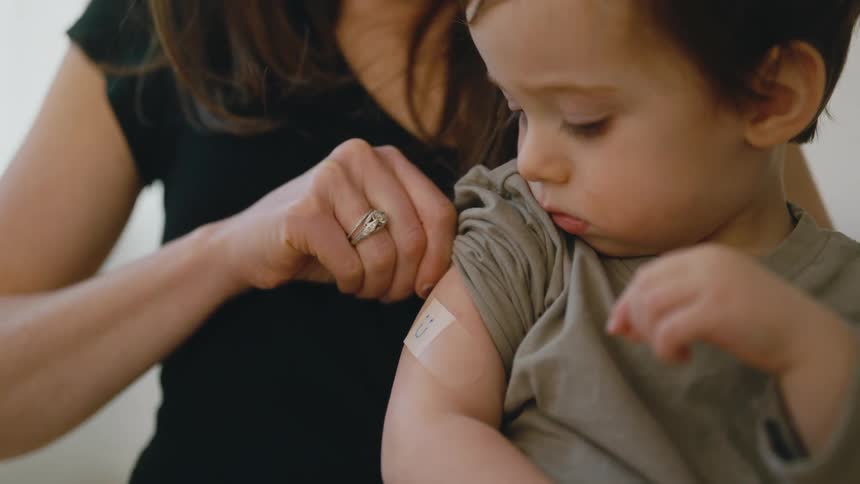 Young boy gets a smiley on his bandaid after vaccination