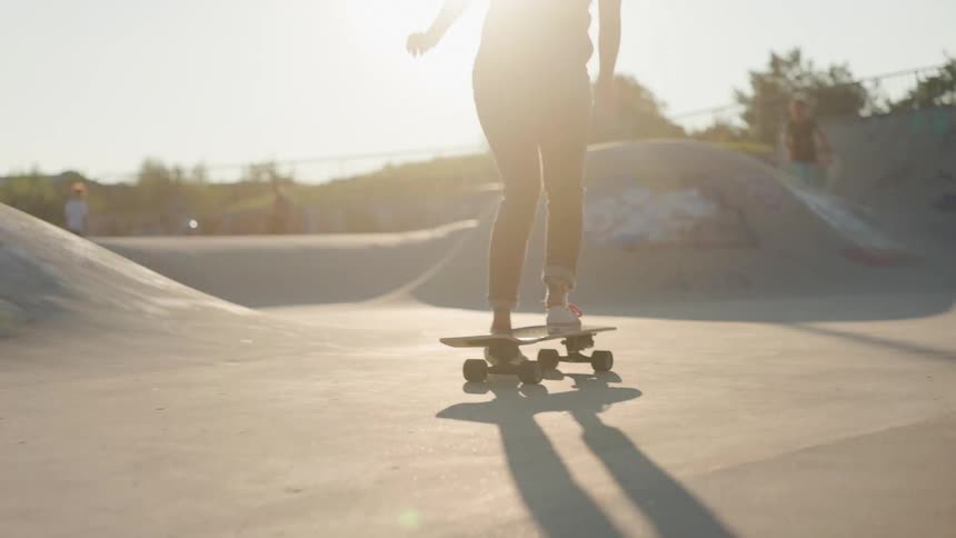 A teenager rides a skateboard in a skate park