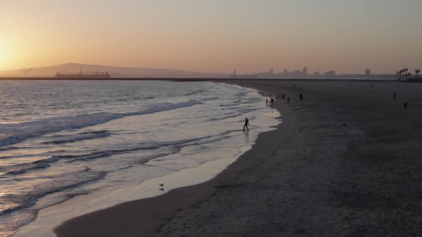 People are hanging out by the beach coast at dusk