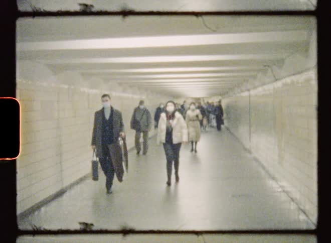 Group of people wearing covid masks walk through a tunnel
