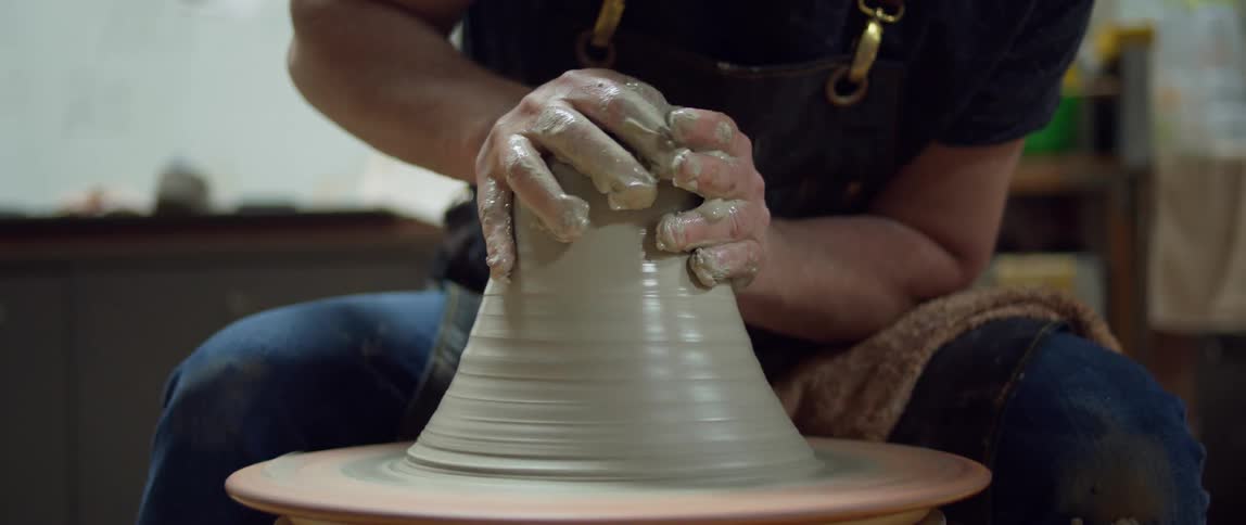A man is sculpting a bowl