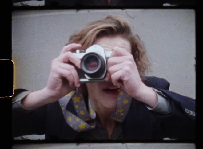 Man with fair wavy hair naval blue blazer jacket takes photo with camera