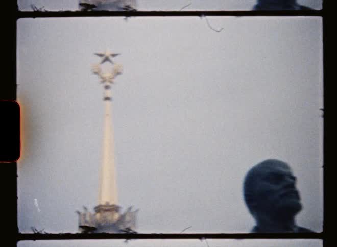 Vintage footage of a statue standing in front of a tower