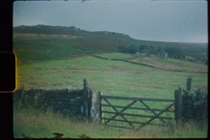 A wooden gate blocks the entrance to a ranch