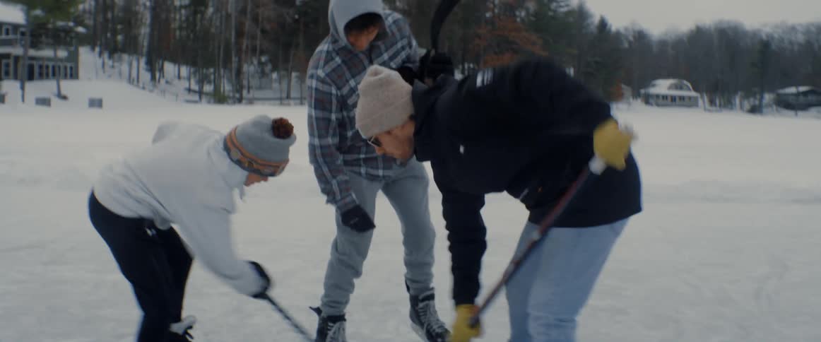 A group of kids tee off during a hockey game on a frozen lake