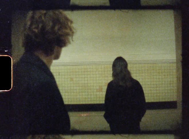 Woman walks away from a man on a subway station caught on vintage film