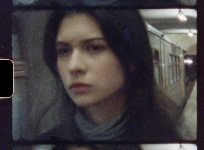 Footage of a woman standing at a train station