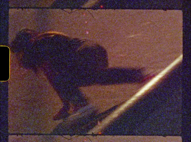 Skateboarder attempts to ride along side of skate bowl and falls off board