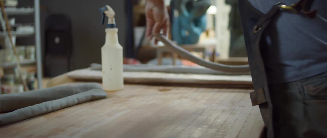 An artist rolls out clay in his studio