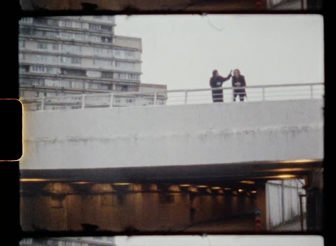 A man and woman talk on top of the parking garage