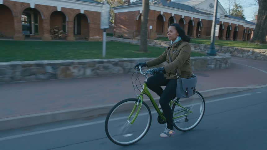 A woman riding her bike on campus
