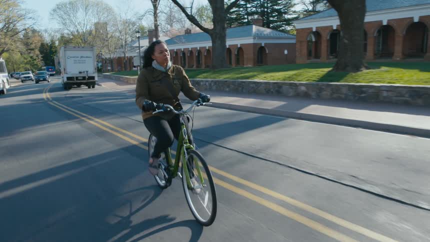 Woman rides her bike on college campus