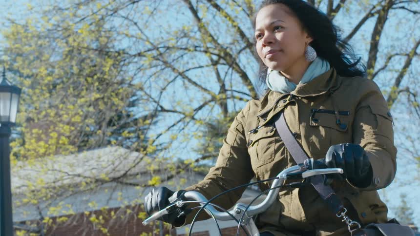 A woman riding her bike on campus