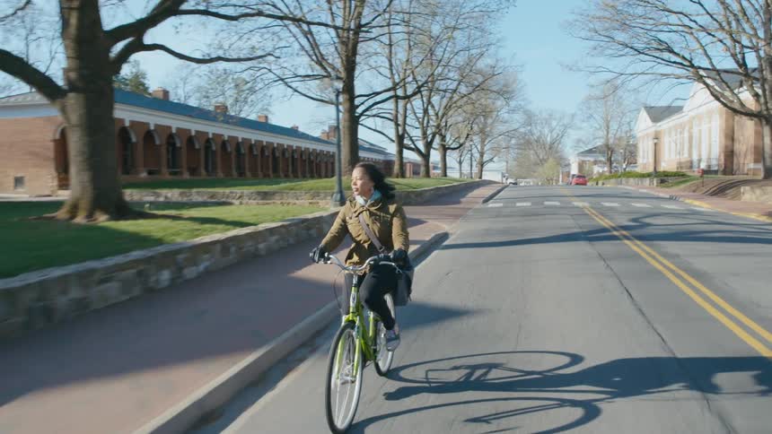 Woman rides bike through campus