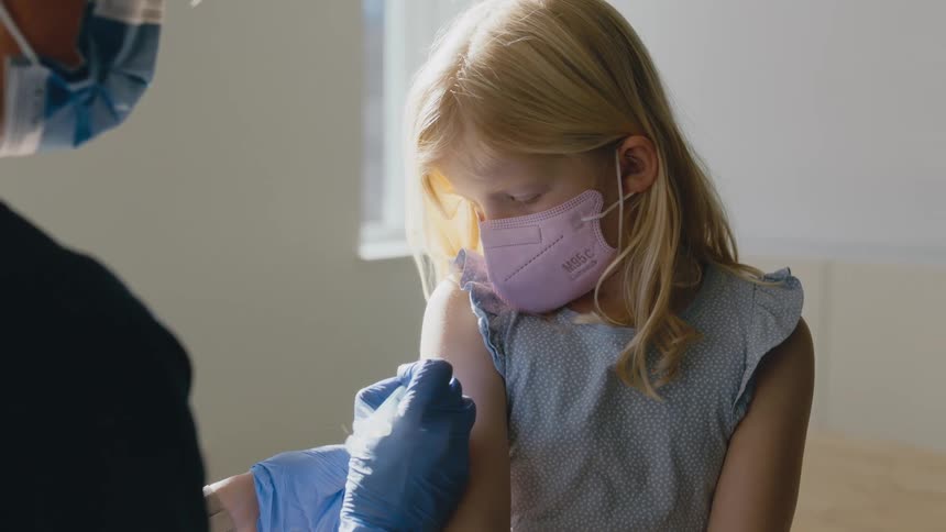 A nurse gets ready to give a little girl a shot