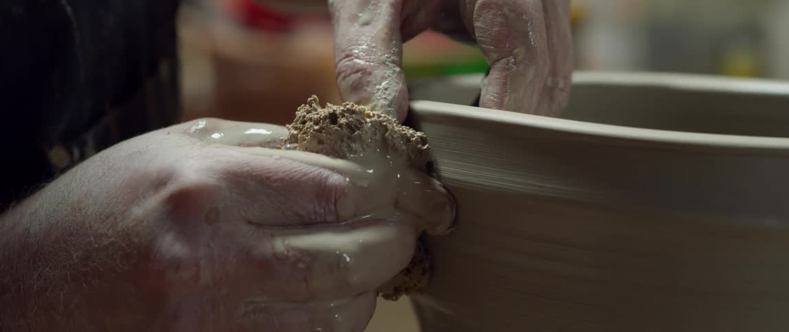 A person is sculpting a vase
