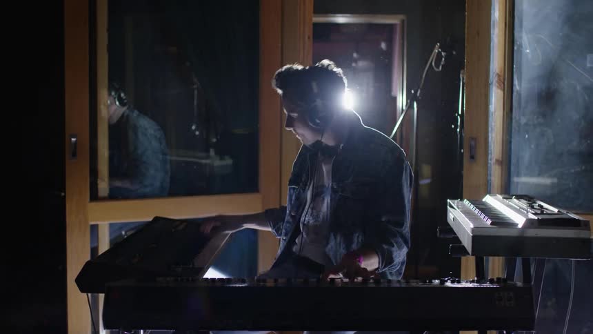 Man playing a keyboard in a studio