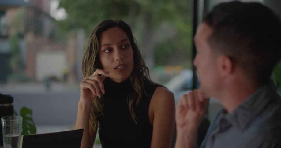 A man and woman sit in an office and talk