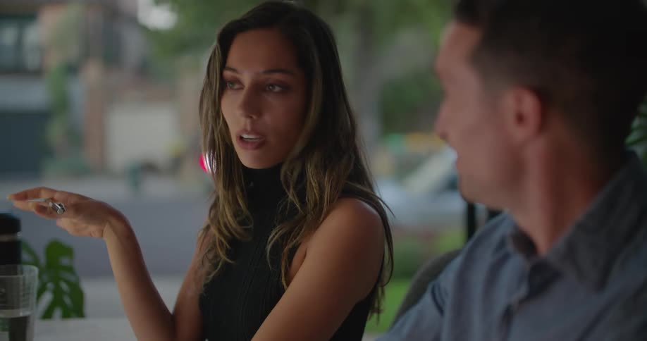 A male and female look at a computer screen while having a conversation