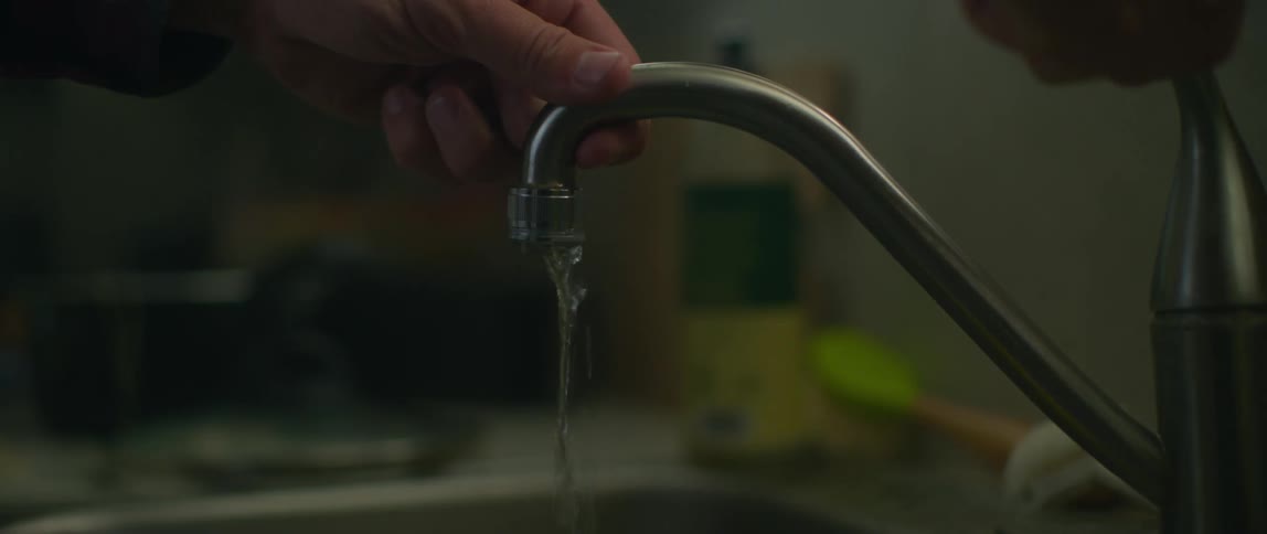 Man jiggles the kitchen sink when the water will not flow at full speed