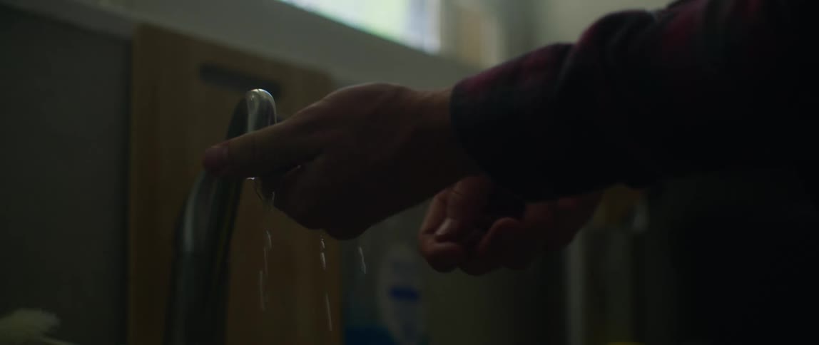 A person unsuccessfully attempts to stop a faucet from leaking
