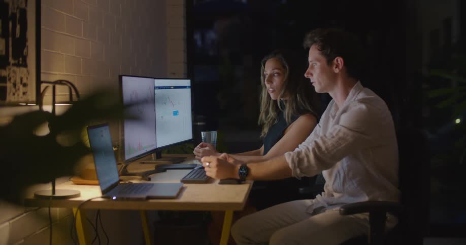 Man and woman are talking and looking at a computer monitor