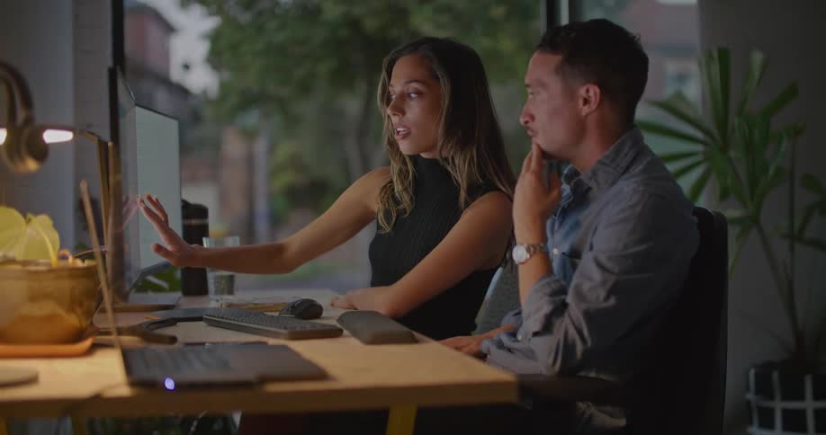 Man and woman are talking and looking at a computer screen