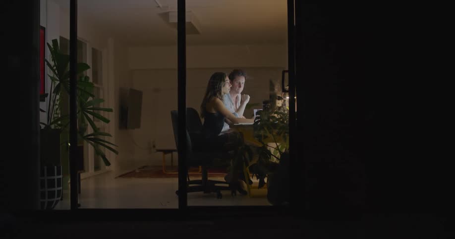 Coworkers sit in office at night having a discussion