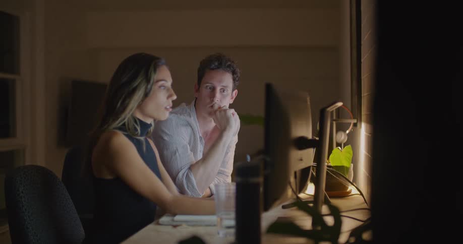 Coworkers sit in office at night having a discussion