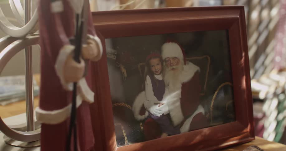 A frame has a photo of santa with a girl on his lap