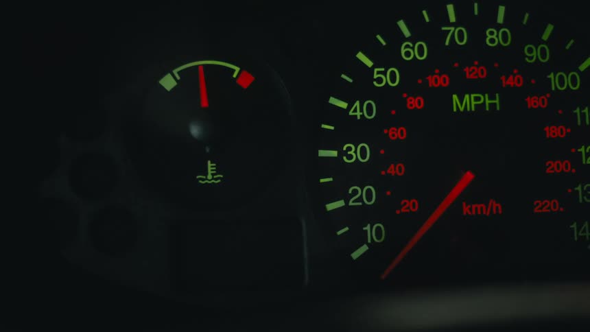 A speedometer and gas gauge inside an automobile and the left blinker is on