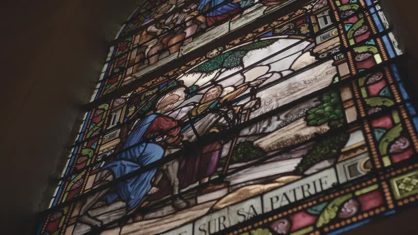 Light illuminates the image on a stained glass window