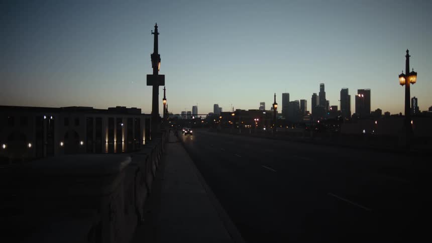 A view of a bridge next to a city with cars driving on it