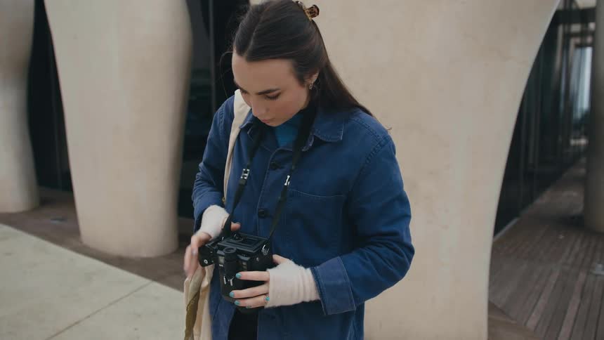A woman is loading film in her camera