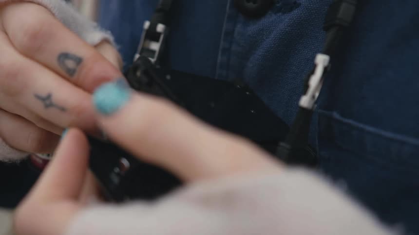 Woman with sparkly nail polish adjusts the controls on a camera