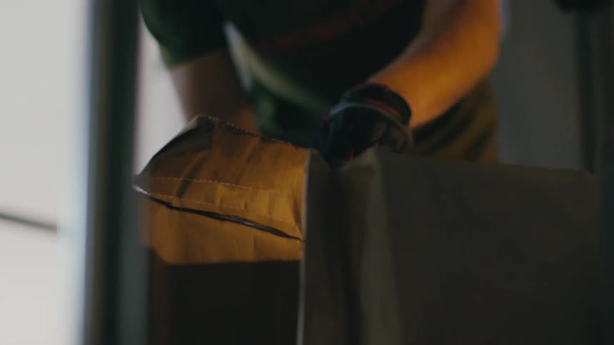 A man lifts a bag in the warehouse