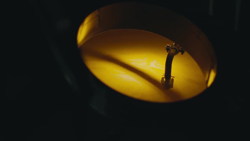 A pipe sits in a round container of liquid