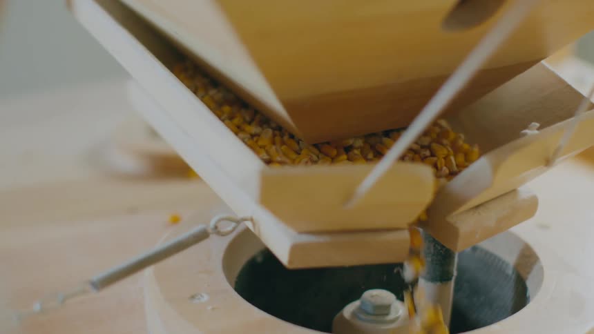 Distillers grain being shaken into wooden mill