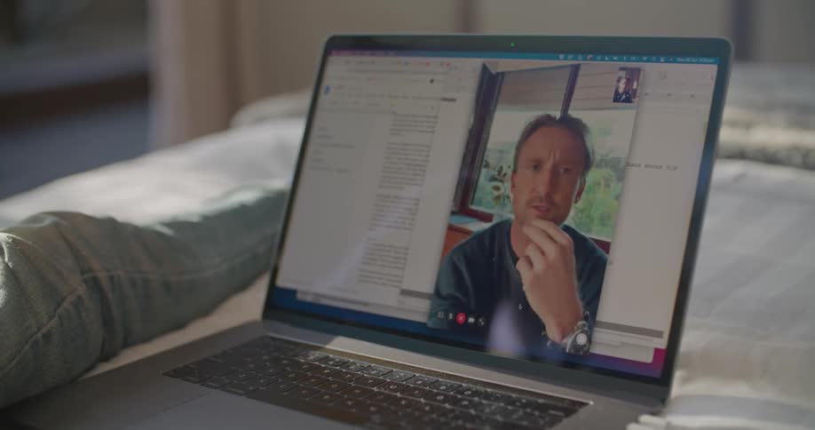 A man is talking on the laptop screen