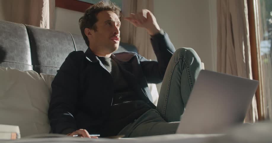 A man sitting around talking on a laptop
